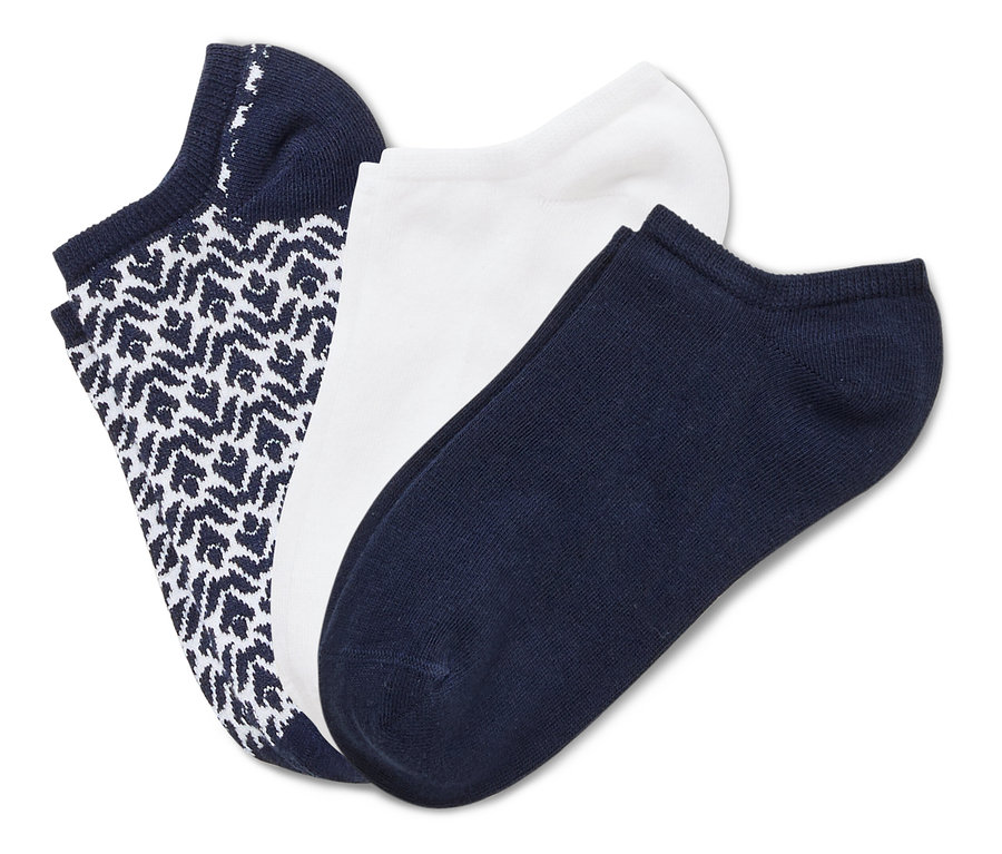 Trois chaussettes sont superposées : une chaussette bleu marine à motifs, une chaussette blanche et une chaussette bleu marine.