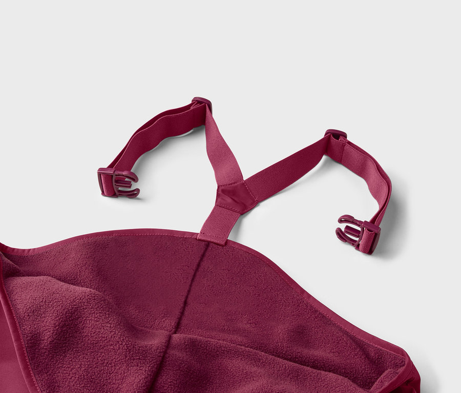 Gros plan d'un poncho de bain bordeaux avec doublure en polaire et bretelles réglables avec boucles sur un fond gris clair.
