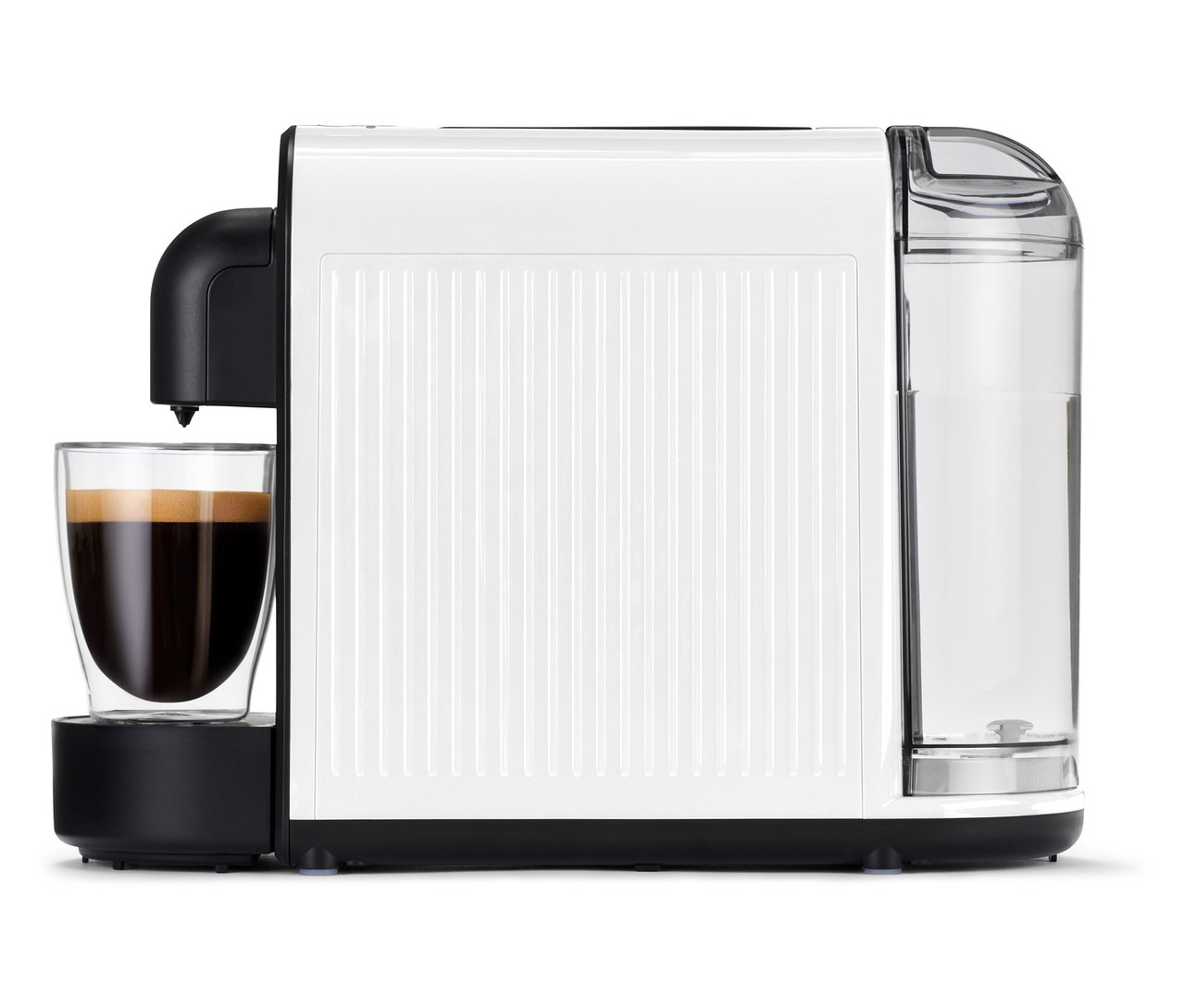 La machine à café blanche Cafissimo now white avec un verre plein est posée sur une table.