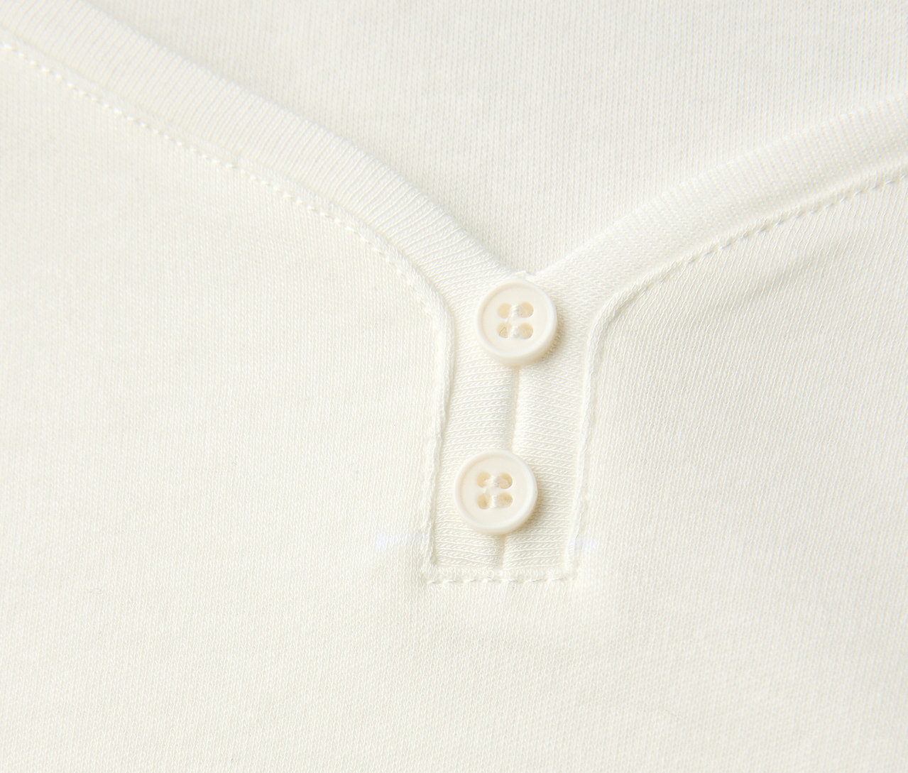 Gros plan sur un maillot 3/4 blanc avec détail bouton Street One.