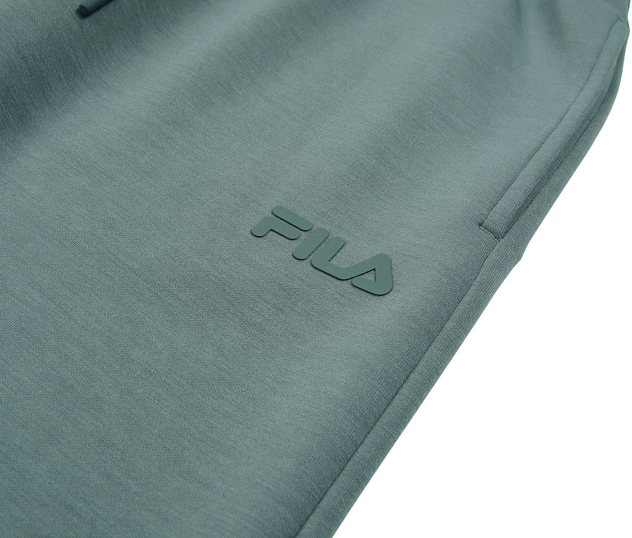 Gros plan d'un pantalon de survêtement Fila turquoise avec cordon de serrage.