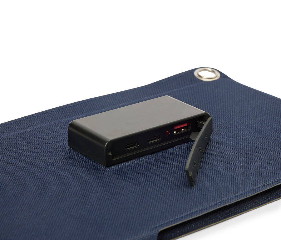 Une batterie noire posée sur une surface en tissu bleu, avec le port USB visible.