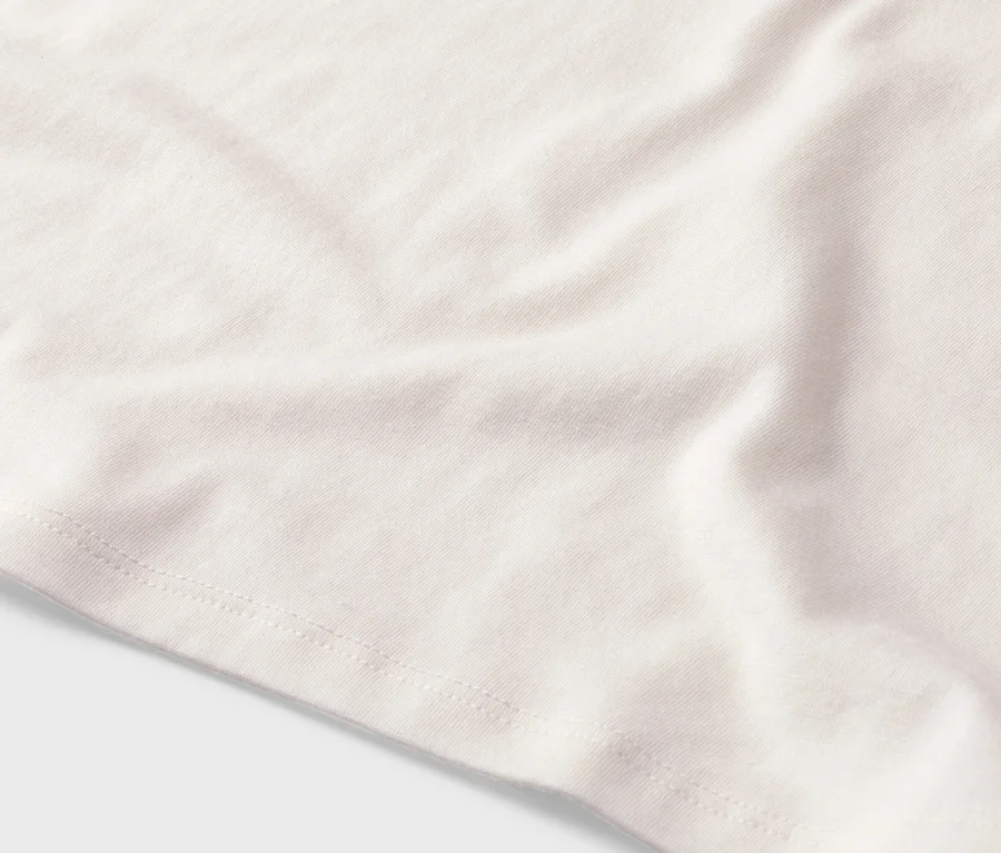 Gros plan d'un tissu blanc avec une couture visible.