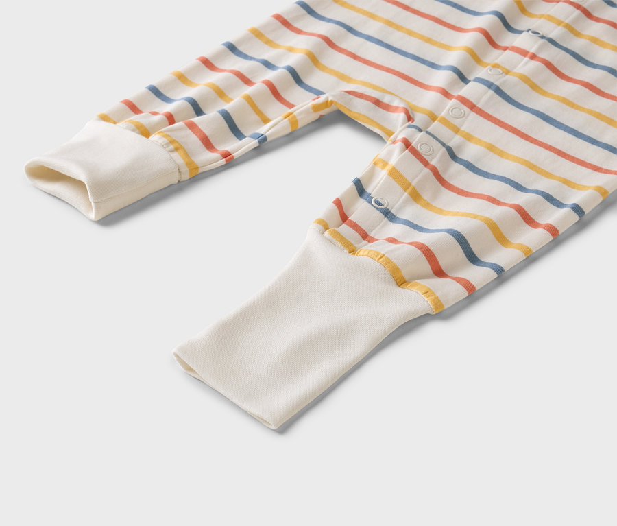 Gros plan sur un pyjama rayé pour bébé avec des poignets blancs.