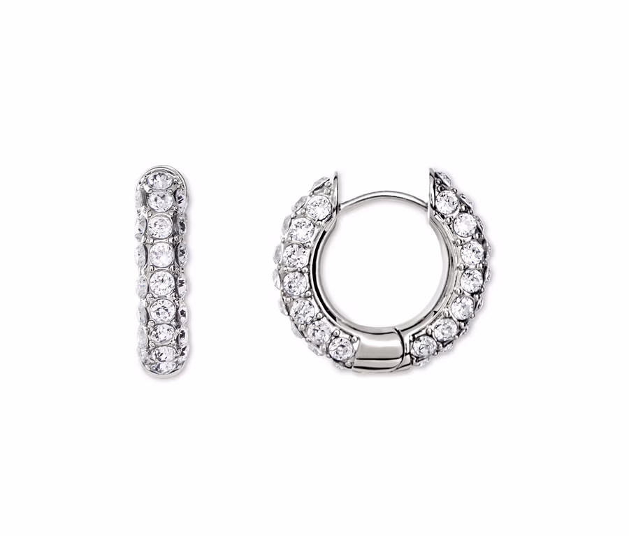 Gros plan de deux boucles d'oreilles créoles argentées serties de strass blancs.