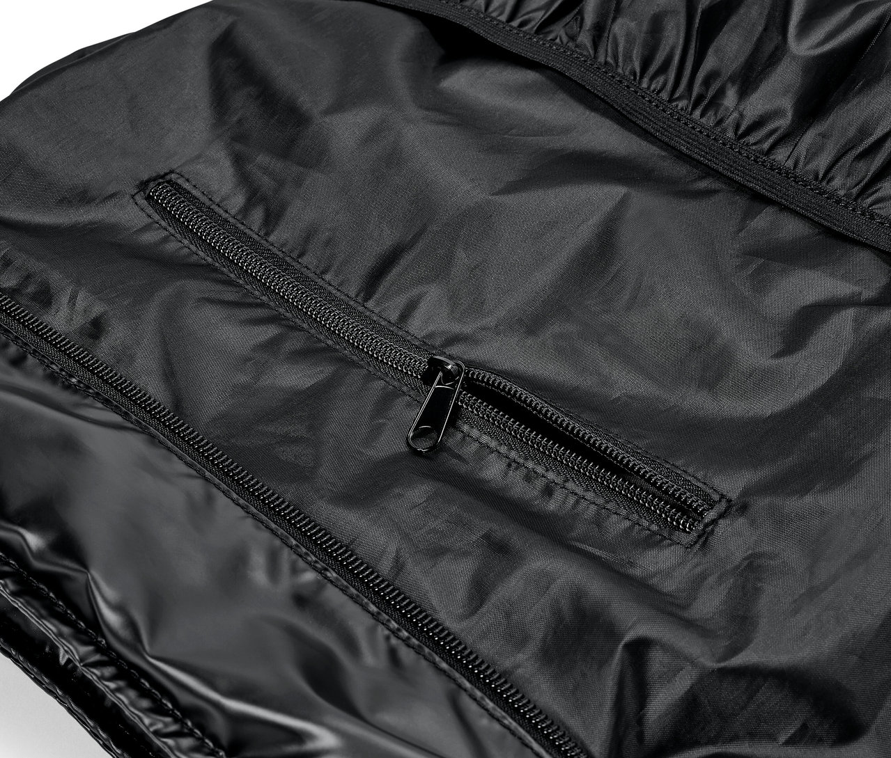 Gros plan d'un vêtement noir brillant avec des fermetures éclair.