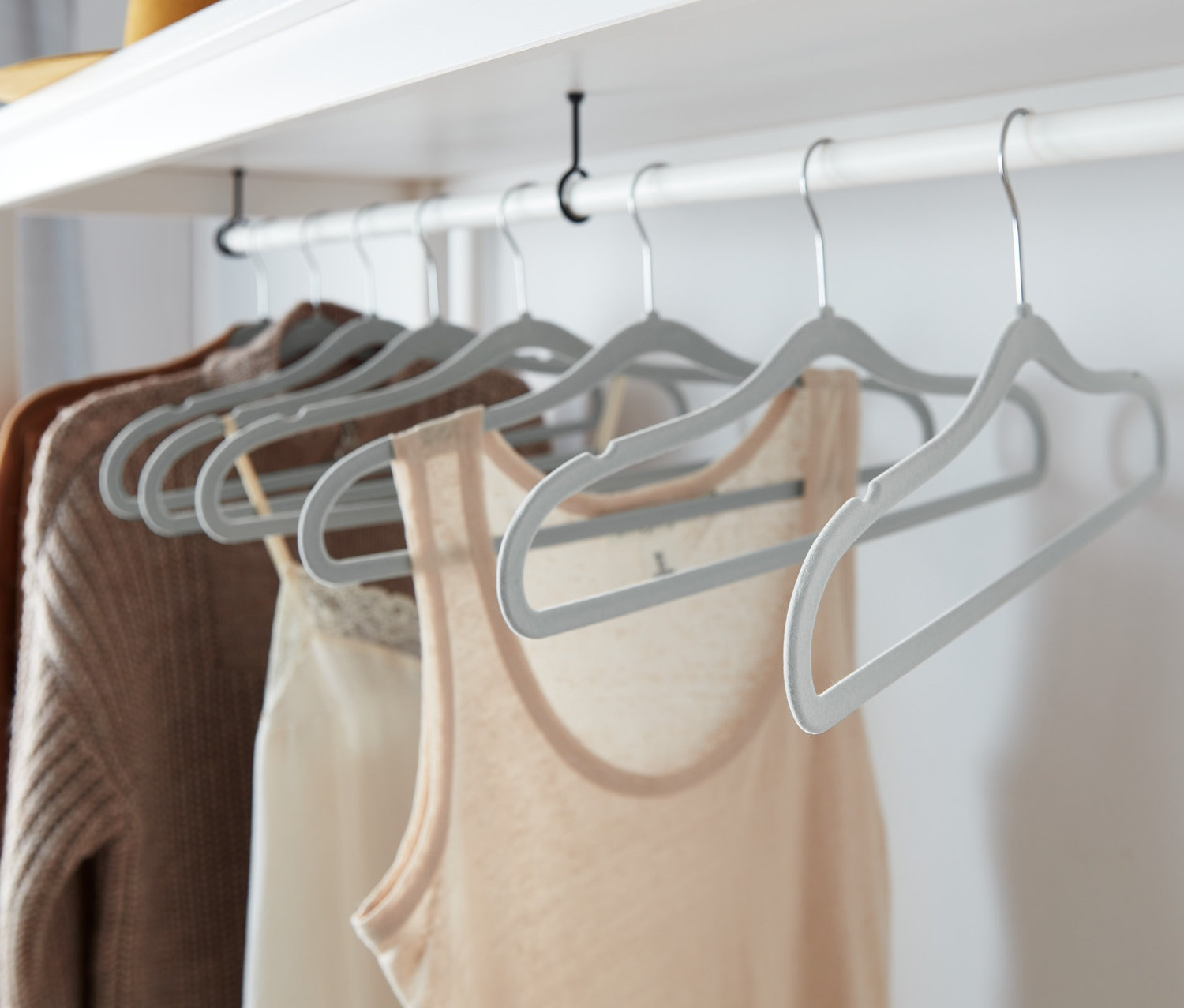 Des vêtements sont suspendus à 8 cintres gris ultrafins.