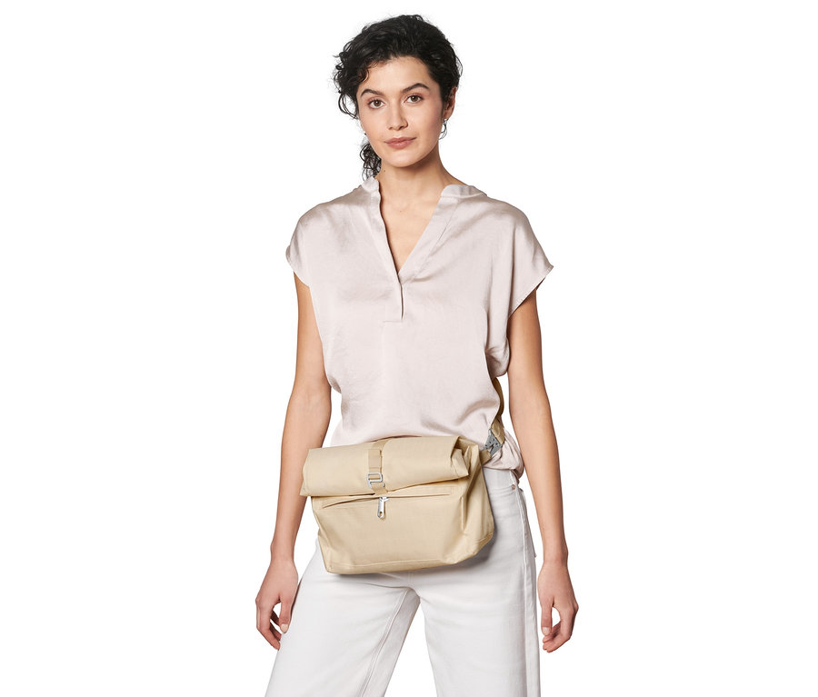 Femme portant un sac à bandoulière de sécurité beige.