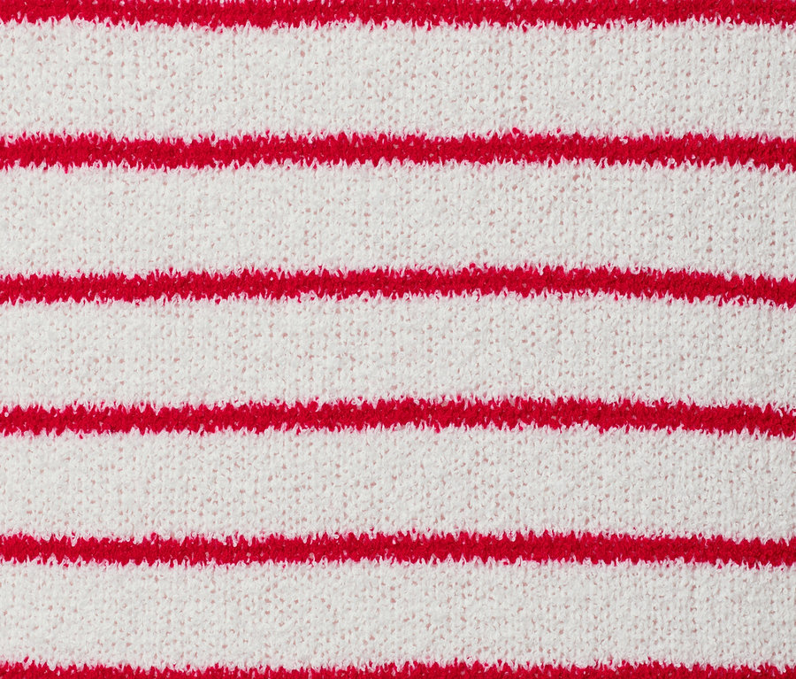 Gros plan sur une jaquette en maille d'aspect bouclé rayée rouge.