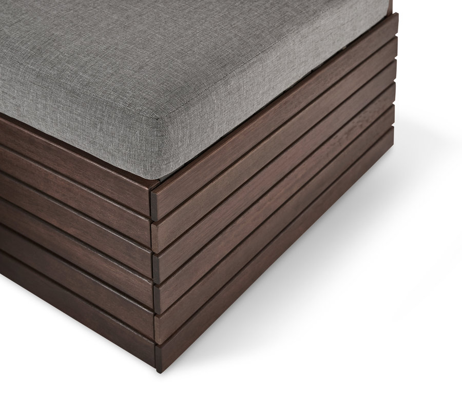 Détail d'un module de pied avec coussin de relaxation confortable. Structure en bois marron avec coussin gris.