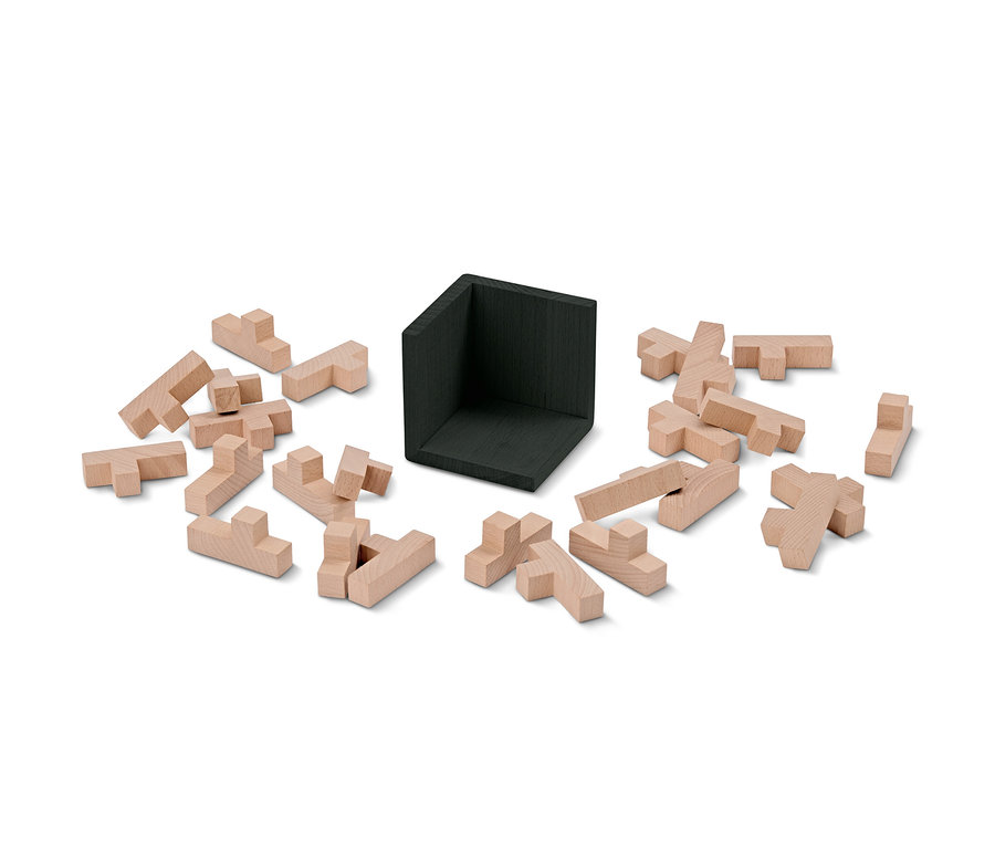 Un cube puzzle QI démonté avec des pièces en bois et une pièce d'angle noire.