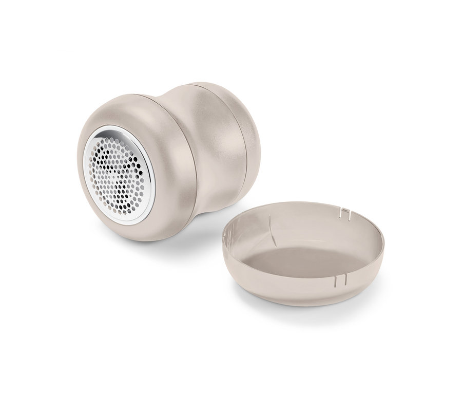 Un rasoir à bouloches et son collecteur de bouloches amovible sont posés l'un à côté de l'autre.