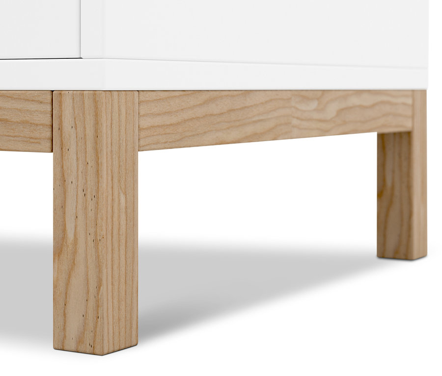 Gros plan d'un buffet blanc avec des pieds en bois.