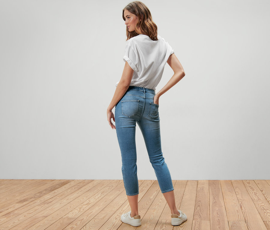 Une femme pose, dos à la caméra, portant un tregging 7/8 – Fit « Nelly » et un t-shirt blanc.