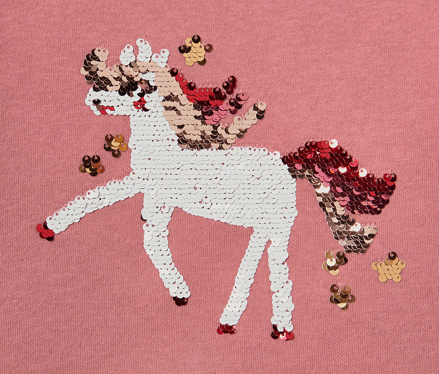 Gros plan sur un sweat-shirt pour enfant avec motif de licorne à paillettes réversibles.