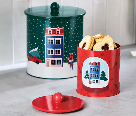 Deux boîtes à biscuits sont posées sur un comptoir de cuisine. Une boîte est verte avec un couvercle et l'autre est rouge et remplie de biscuits.