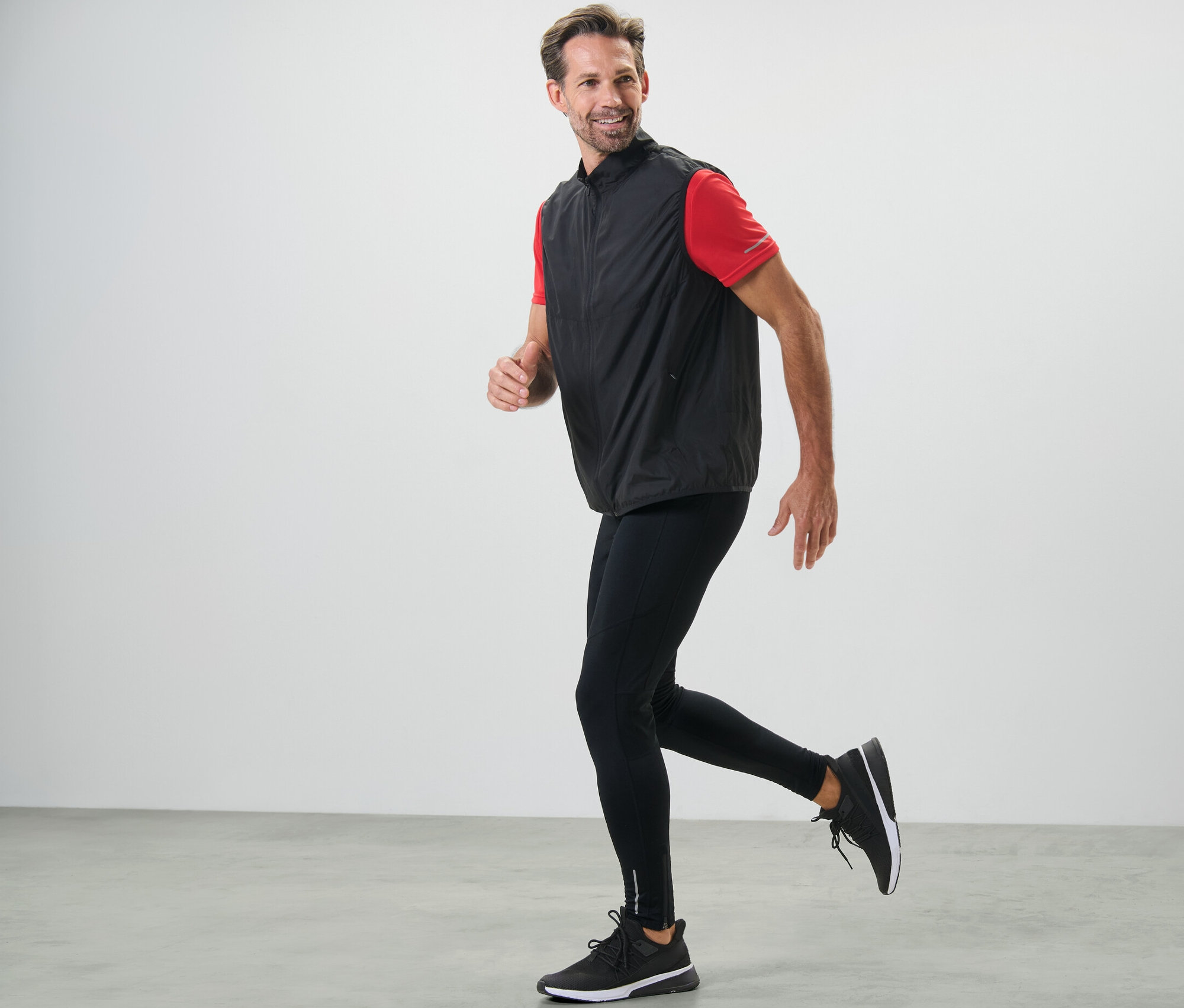 Homme courant en legging de sport noir et gilet.