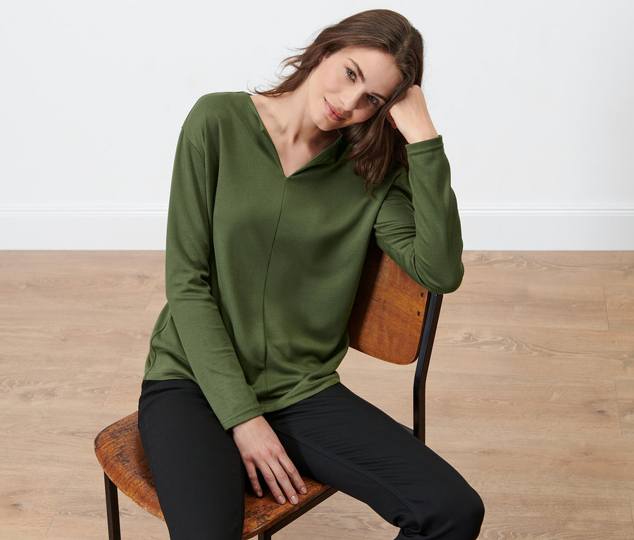 Femme assise sur une chaise portant une blouse.