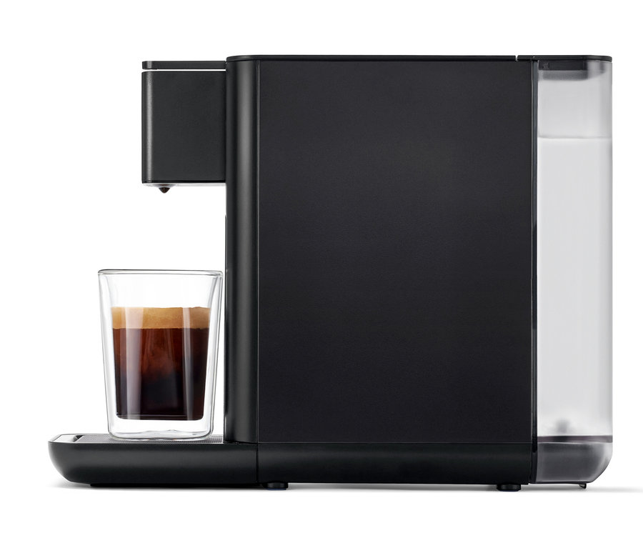 Machine à café Qbo ICONIC Dark Chrome avec une tasse de café.