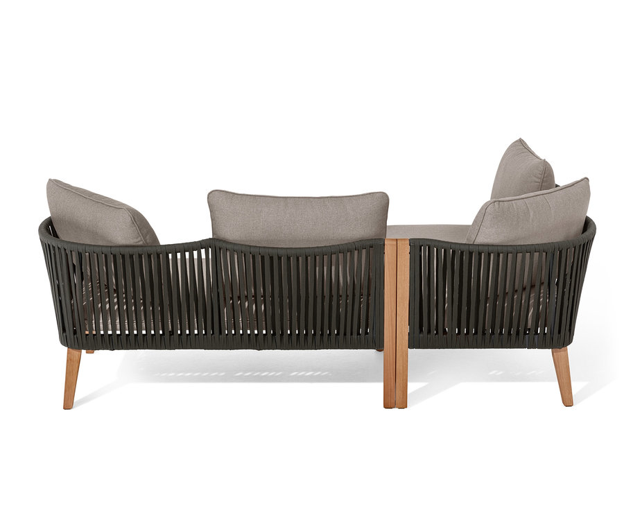 Gros plan d'un coin salon avec tressage textile et coussins gris.