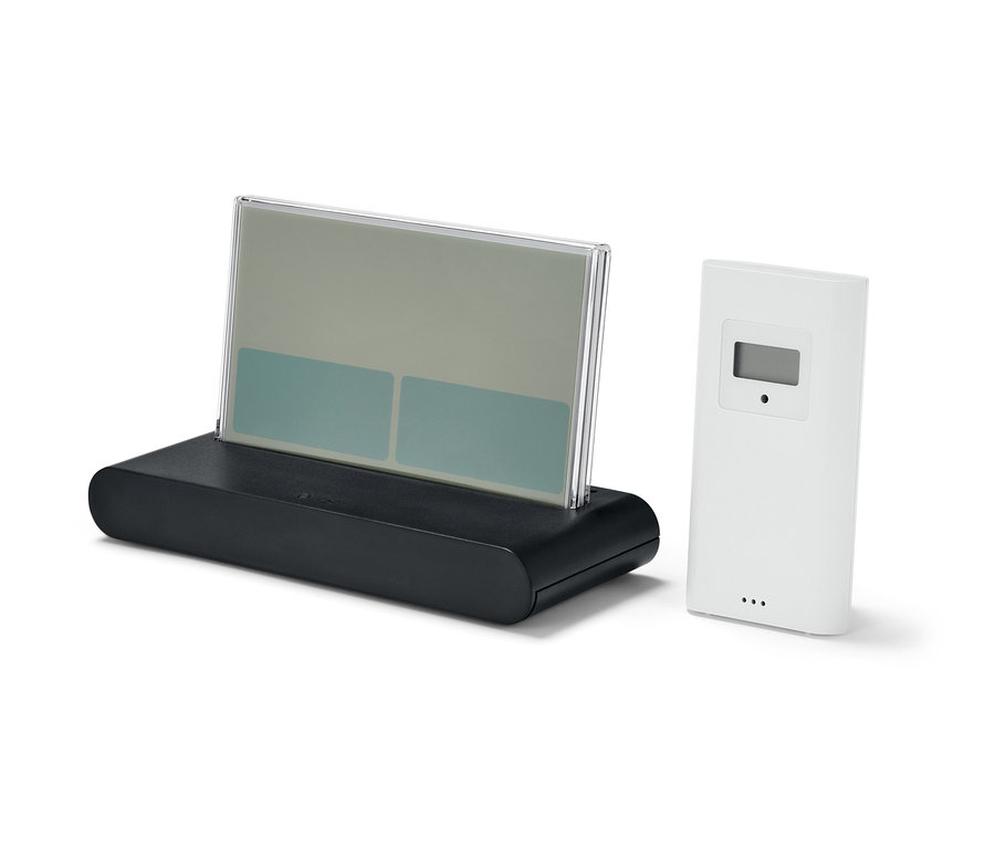 Une station météo radio avec capteur extérieur sur fond blanc.