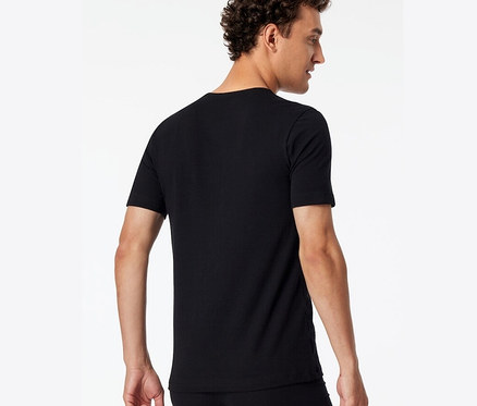 Un homme vu de dos portant un des 2 t-shirts noirs SCHIESSER en coton bio.