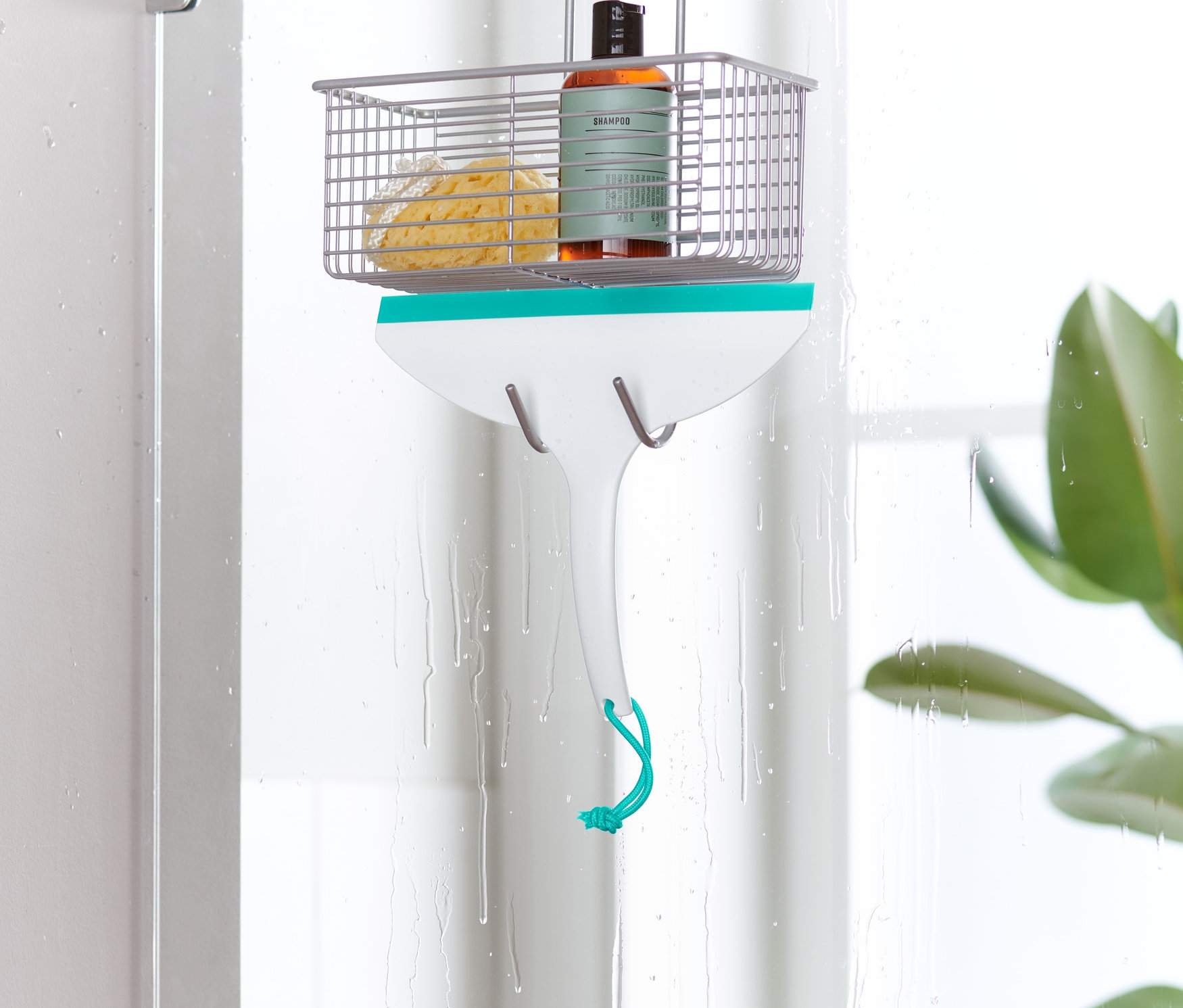 Une raclette de salle de bain est accrochée à une porte de douche.