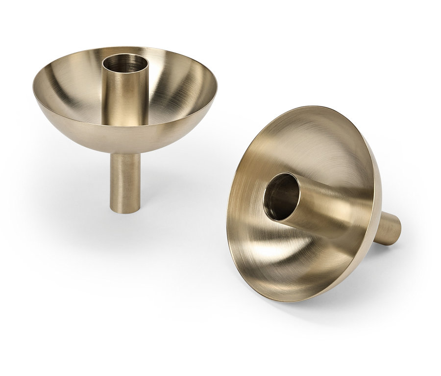 Deux bougeoirs dorés sur fond blanc.