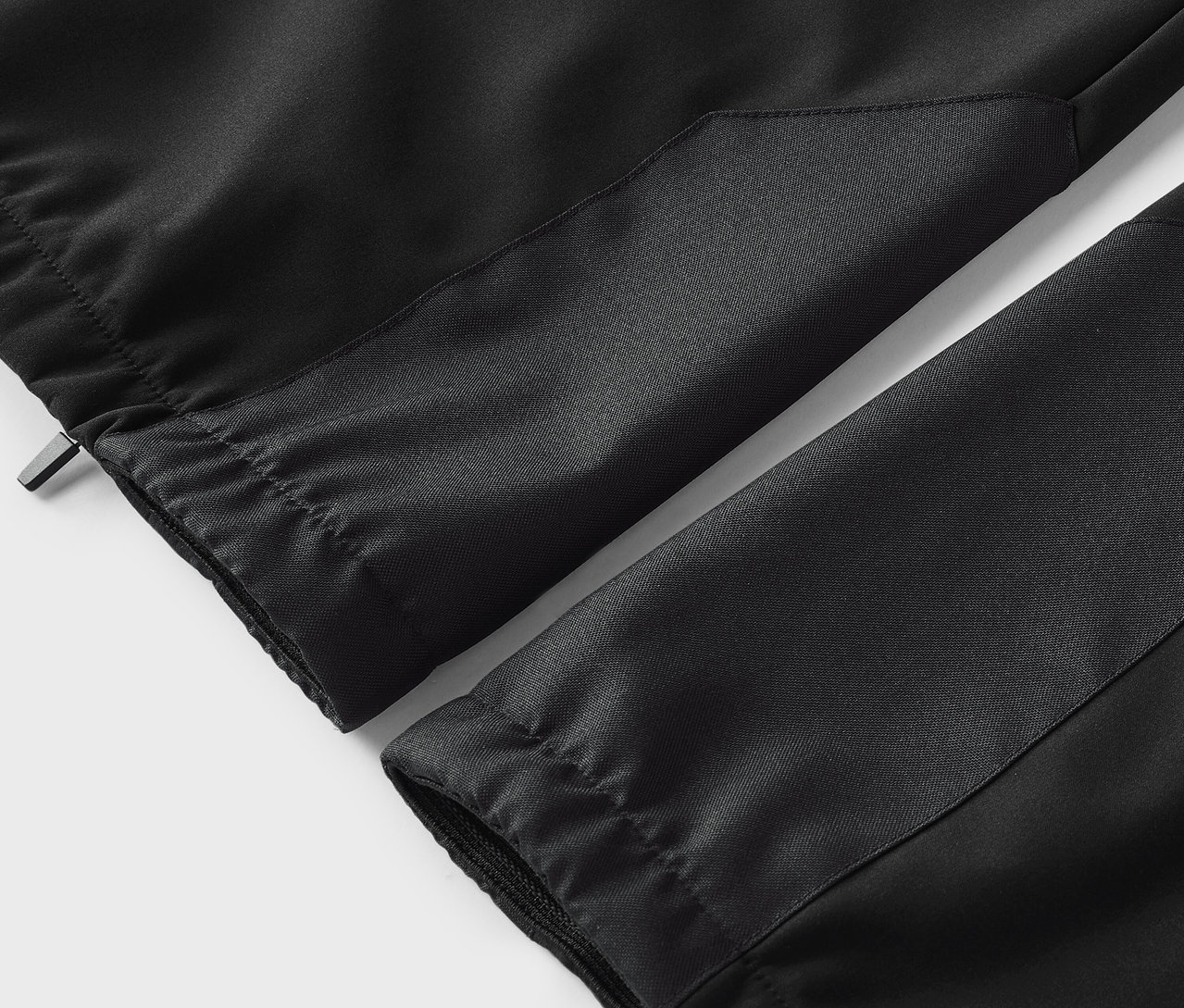Gros plan sur un pantalon noir avec taille élastique et chevilles élastiquées.