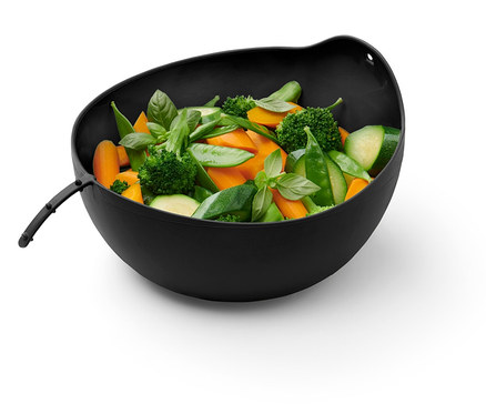 Dans un bol, il y a des carottes coupées, du brocoli, des courgettes, des petits pois verts et du basilic.