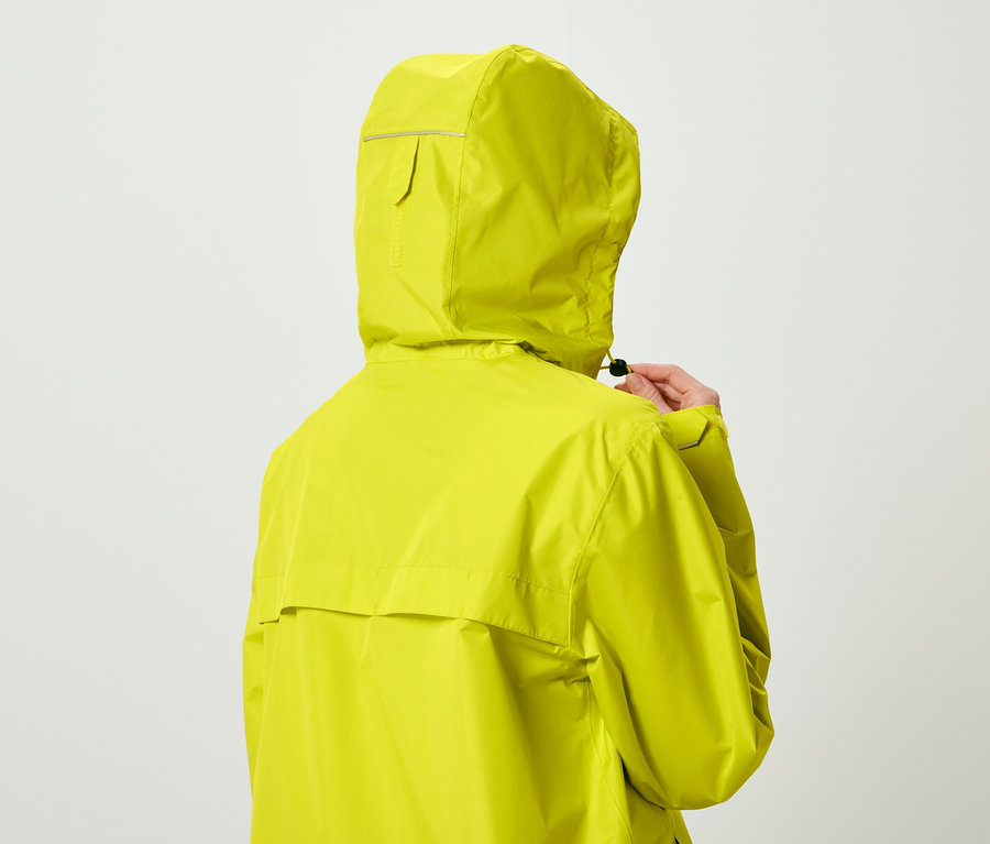 Personne vue de dos portant une veste à capuche jaune citron et ajustant le cordon de serrage.