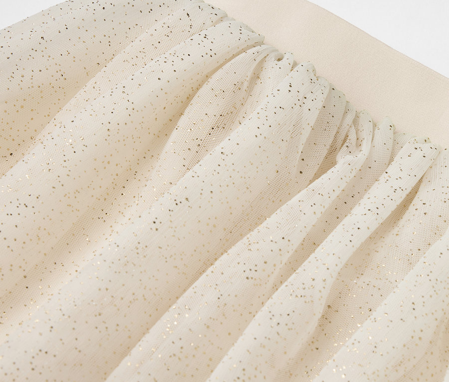 Jupe en tulle beige avec des paillettes argentées.