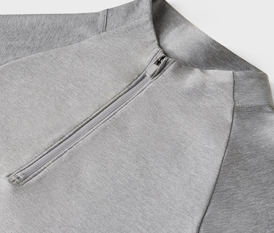 Gros plan d'un sweat-shirt gris clair avec fermeture éclair.