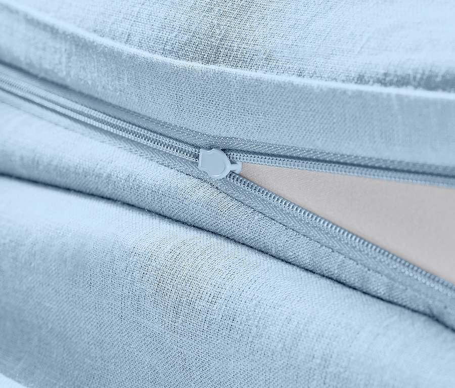 Gros plan sur une parure de lit en lin bleu clair de taille standard avec fermeture éclair.