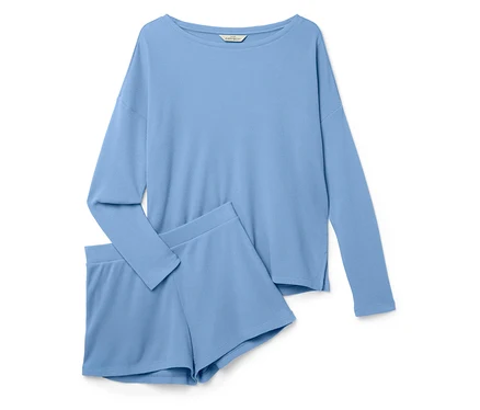 Un ensemble de pyjama bleu clair à manches longues et un short posé sur un fond blanc.