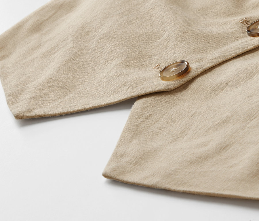 Gros plan sur un gilet en lin avec des boutons.