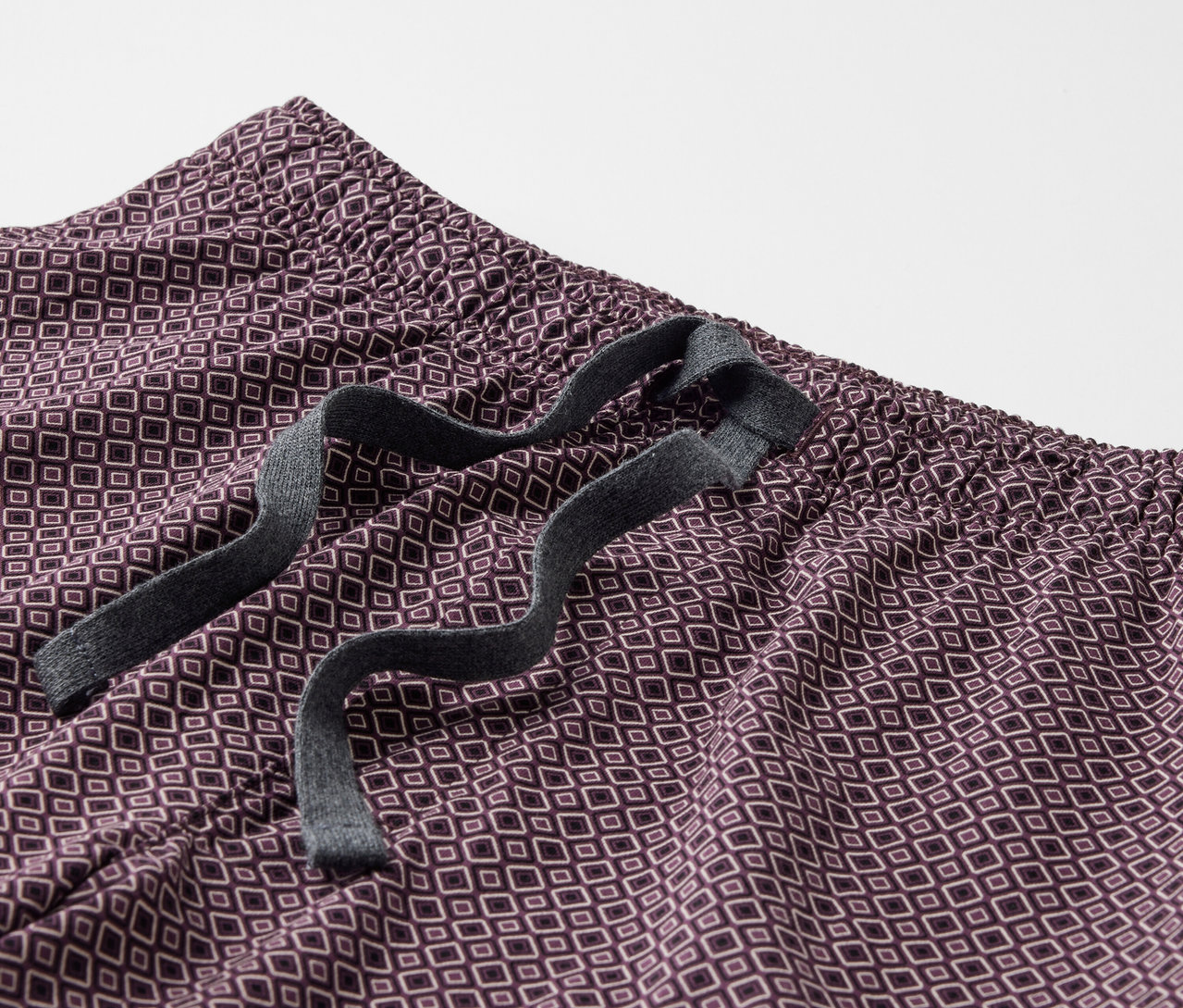 Gros plan sur un shorty de pyjama avec un motif géométrique et un cordon de serrage à la taille.