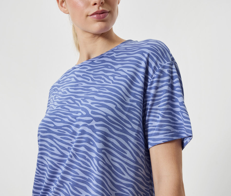Une femme portant un t-shirt bleu à motif animal.