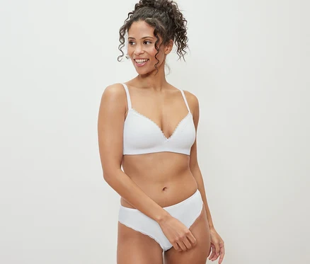 Femme souriante posant en sous-vêtements : 2 slips blancs.