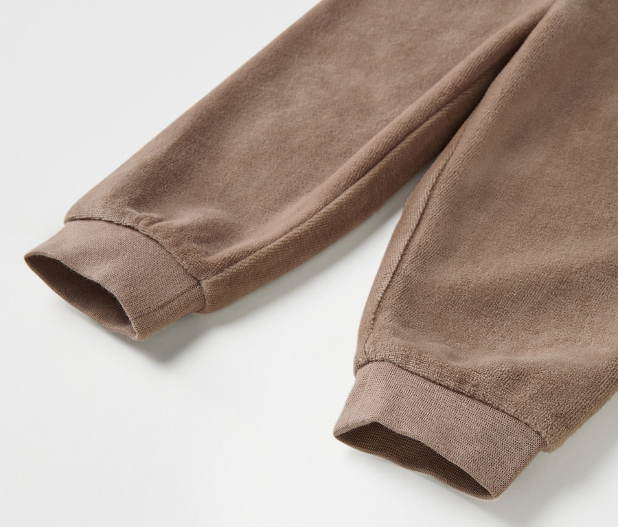 Gros plan sur un ensemble en nicki marron pour bébé avec des manches longues.