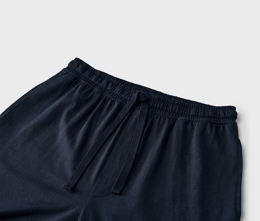 Gros plan sur un pantalon de survêtement bleu marine avec cordon de serrage à la taille.