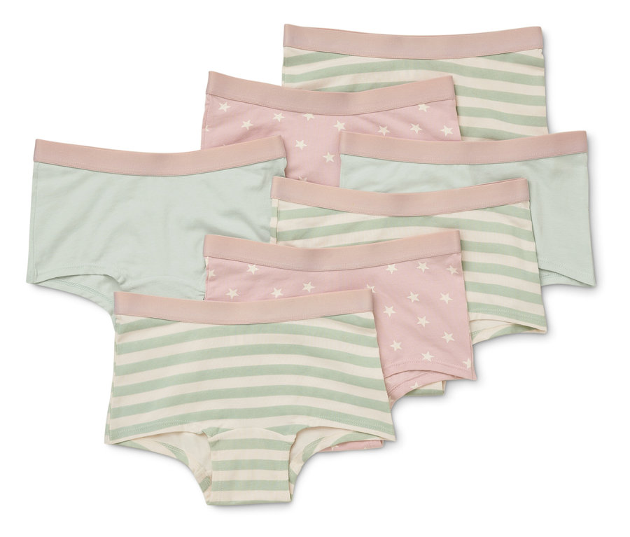 Sept culottes pour enfants empilées, avec différents motifs comme des rayures, des étoiles et des couleurs unies en rose, vert et blanc.