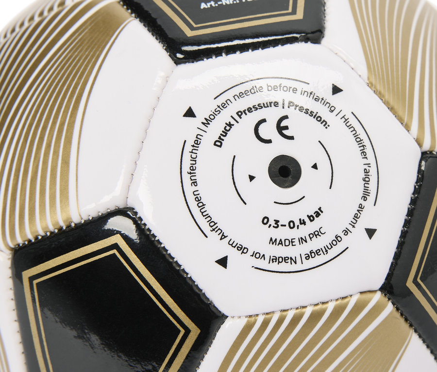 Gros plan d'un ballon de football noir et or avec des panneaux blancs et le marquage CE.