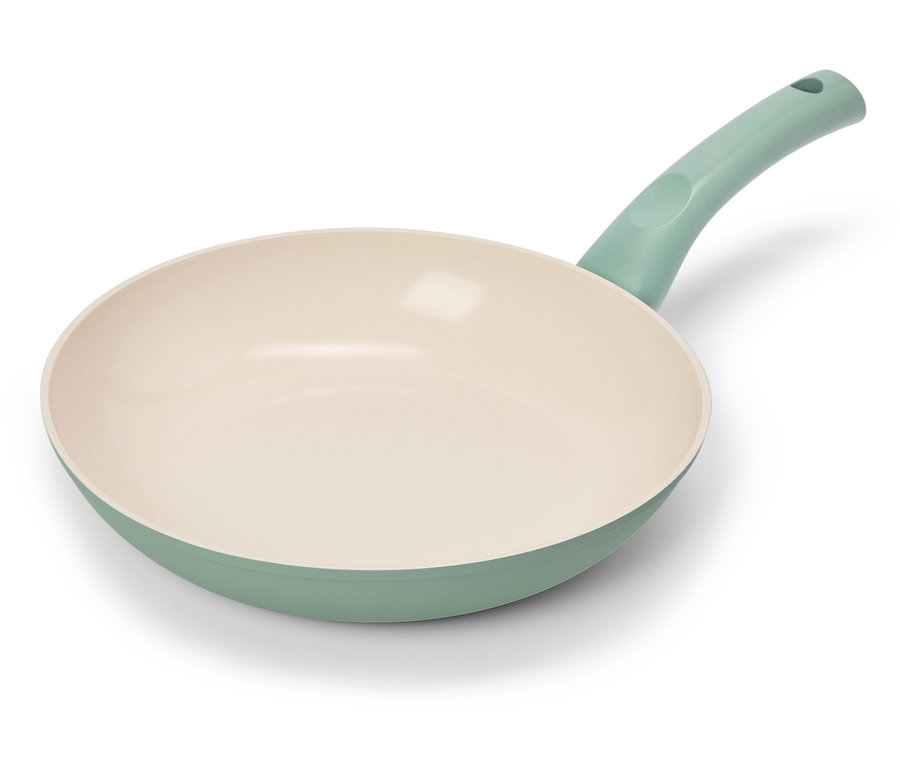 Une seule poêle à frire avec un bord et une poignée vert clair repose sur un fond blanc.