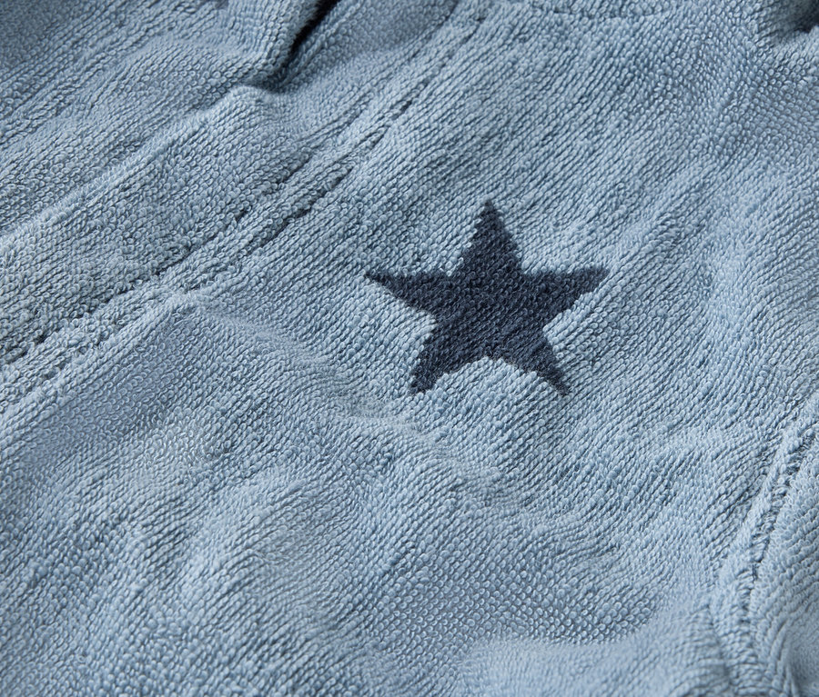 Gros plan sur un peignoir bleu clair avec des étoiles bleu marine.