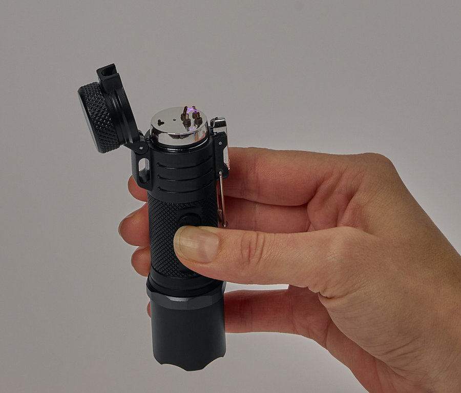 Une main tient un briquet plasma noir avec un couvercle ouvert.