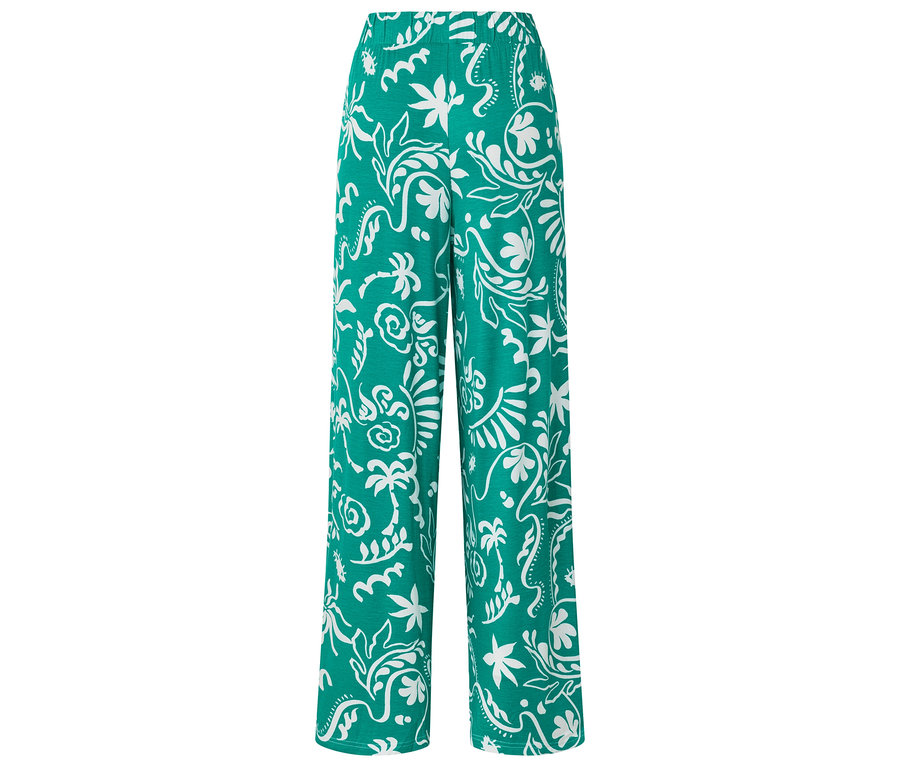 Pantalon vert ample à motifs floraux blancs.