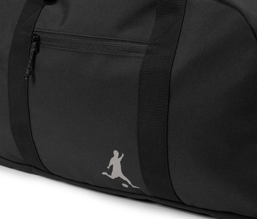 Gros plan d'un sac de sport noir avec une poche zippée et le logo d'une personne jouant au football.