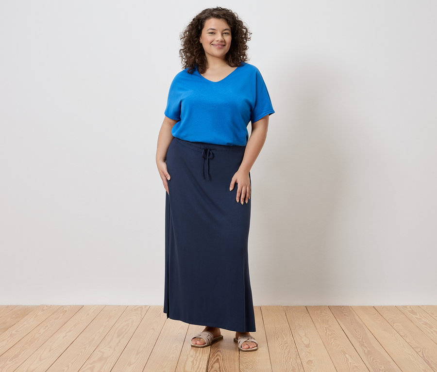 Femme portant un t-shirt bleu et une longue jupe bleu marine.