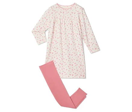 Une chemise de nuit blanche à fleurs roses est posée à côté d'un legging rose.